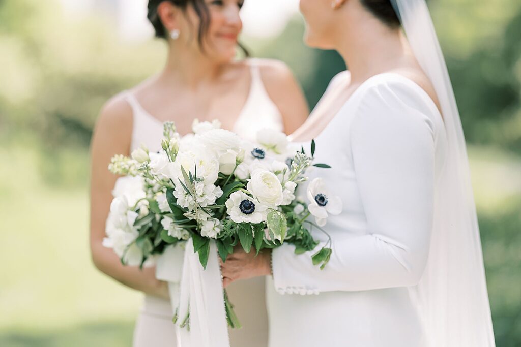 Bridesmaid and bride with white wedding bouquet