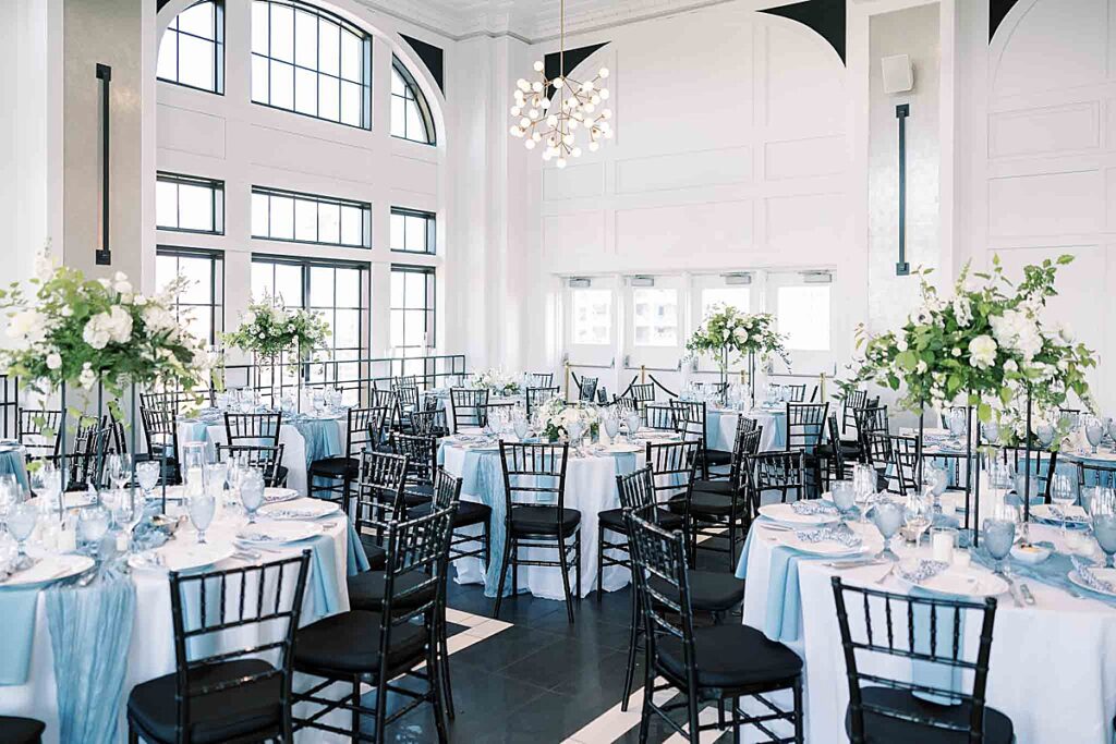 Wedding reception decor with tall white flowers and black and white floor