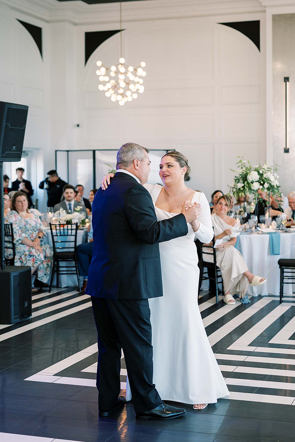 Bride in white dress dances with man in black suit