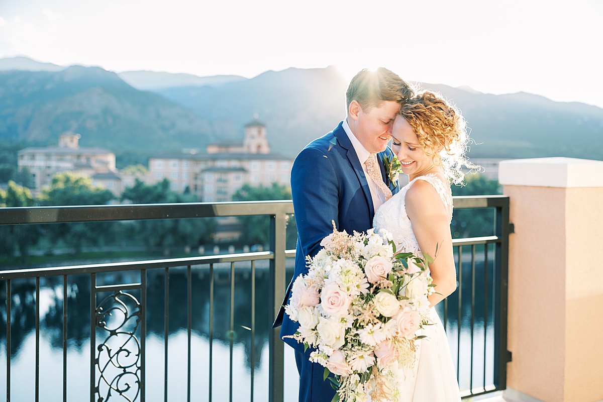 Couple posing with large flowers on balcony at the Broadmoor in Colorado Springs, Colorado