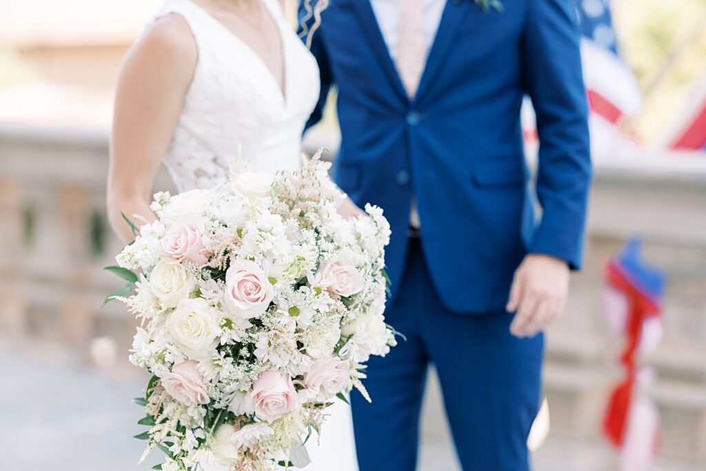 Photo of bride and groom with large pink and white bouquet