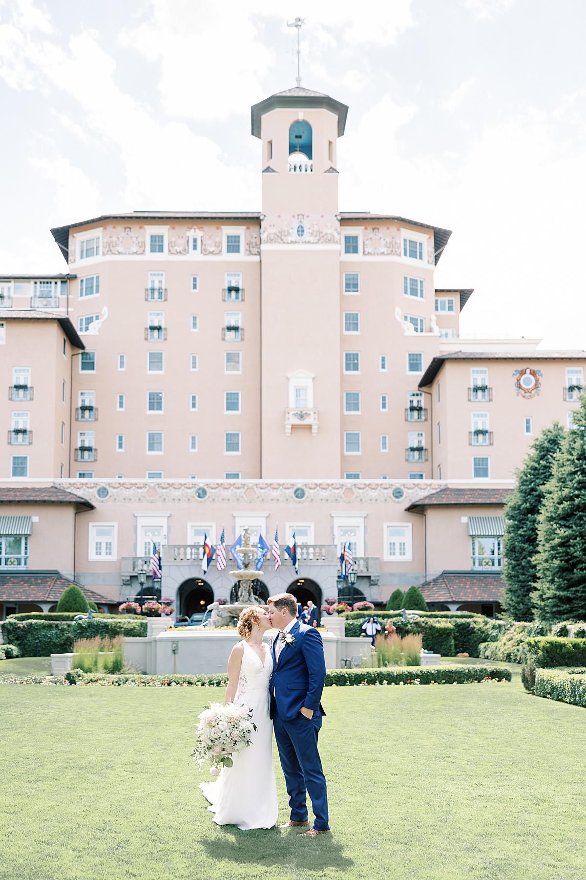 Couple kissing on the lawn in front of the Broadmoor Resort in Colorado Springs, Colorado