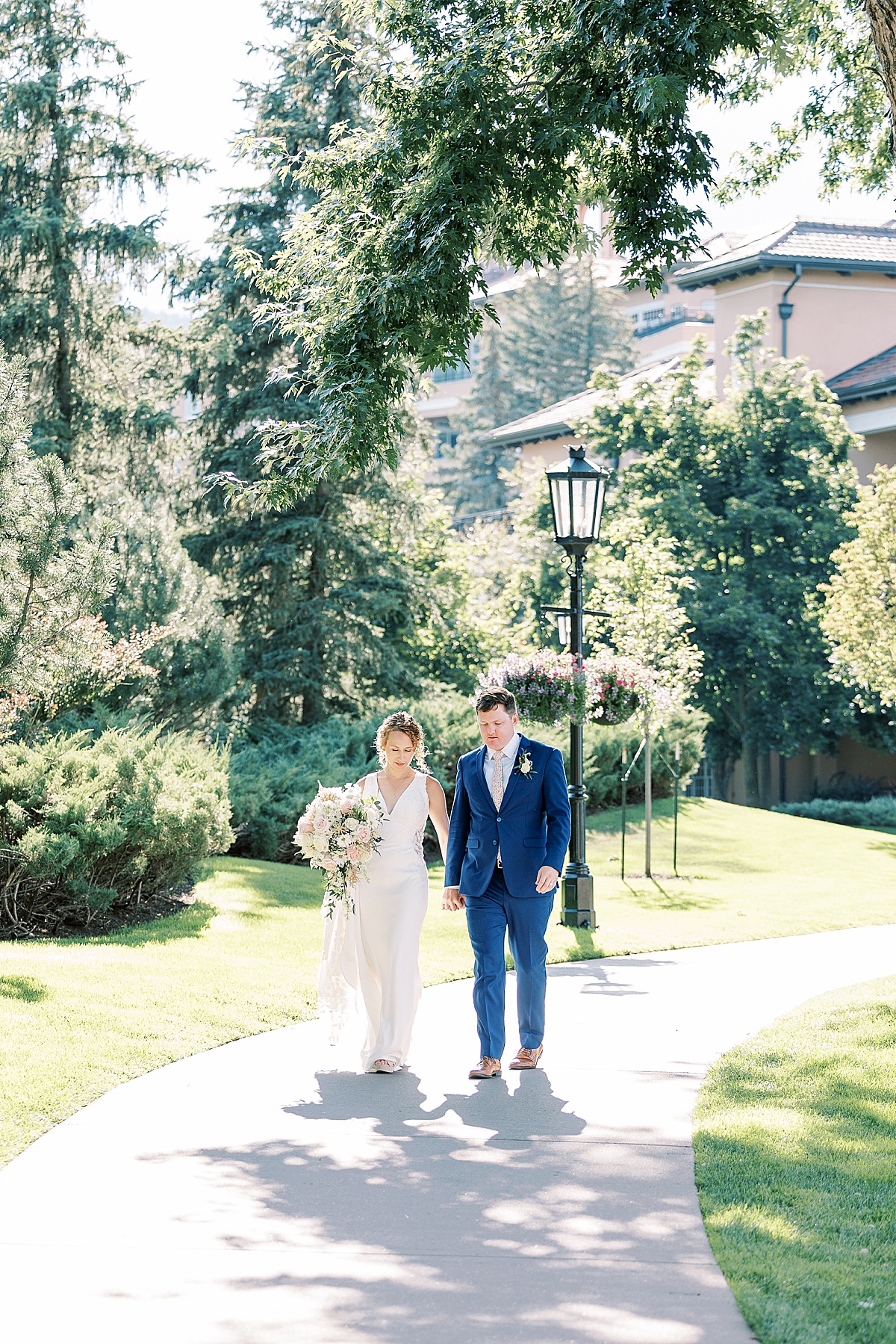 Couple walking on concrete path at the Broadmoor in Colorado Springs, Colorado