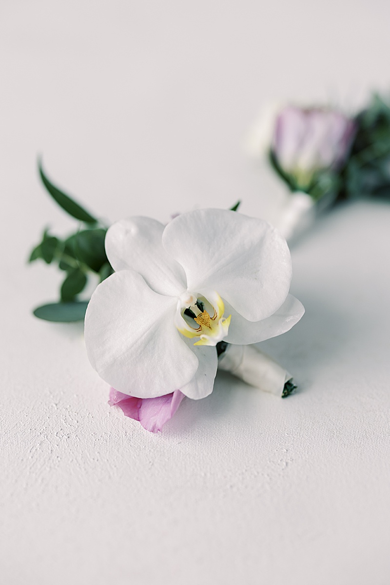 White and purple wedding boutonniere 