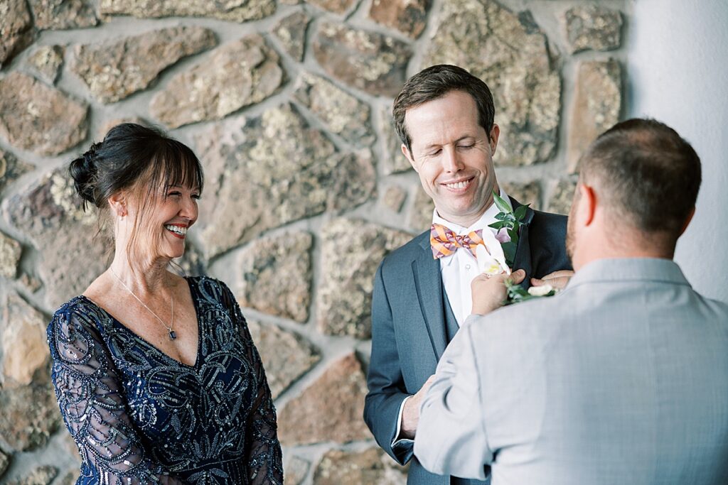 Group of people smiling while putting on boutonniere  