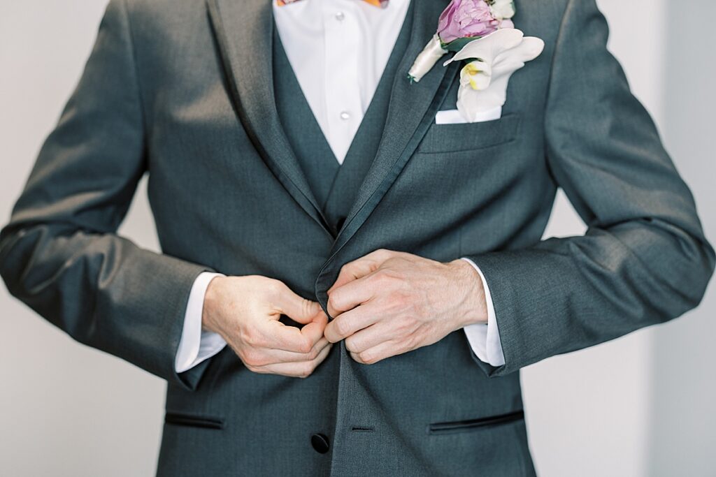 Groom buttoning gray suit