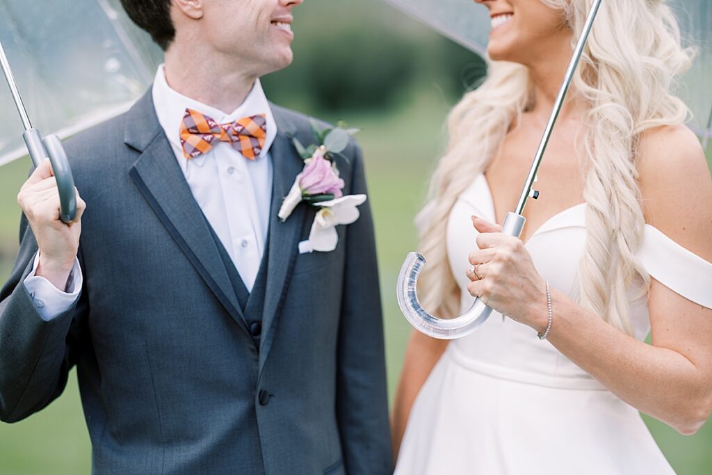 Couple holding umbrellas on their wedding day