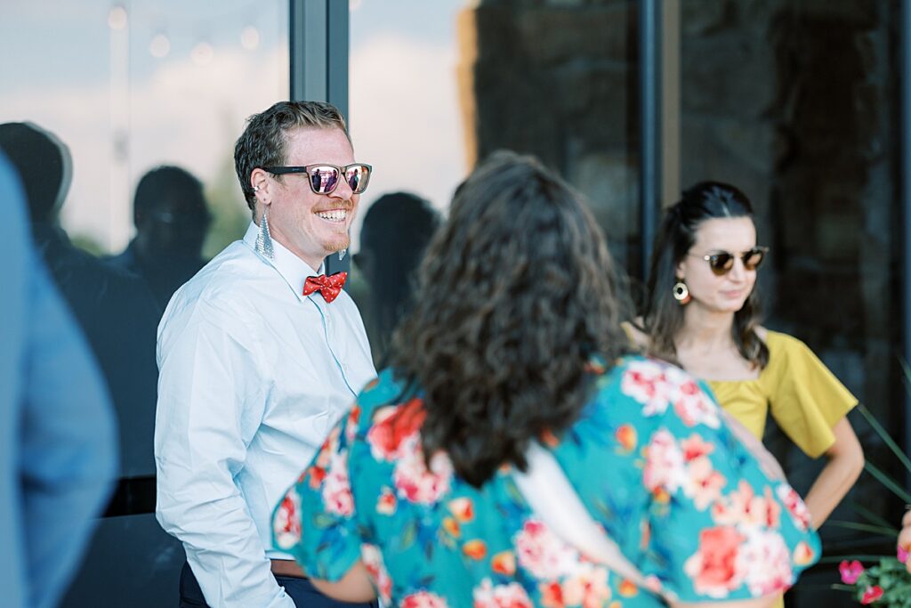 Three wedding guests laughing at cocktail hour