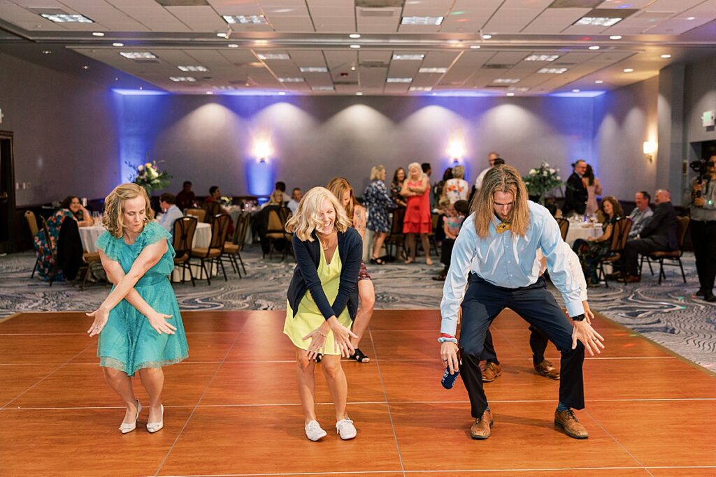 Three people dancing on wooden dance floor