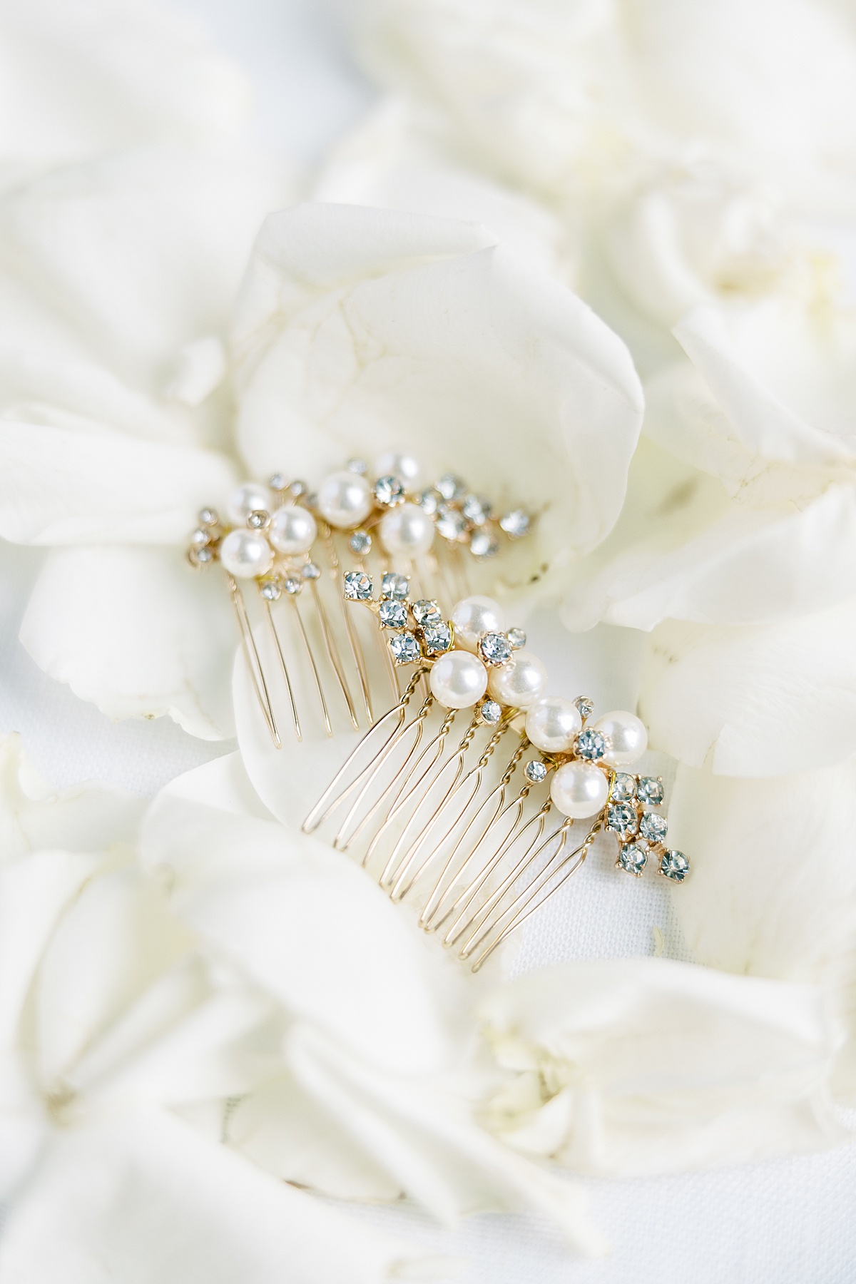 Pearl wedding hair combs laid on white rose petals