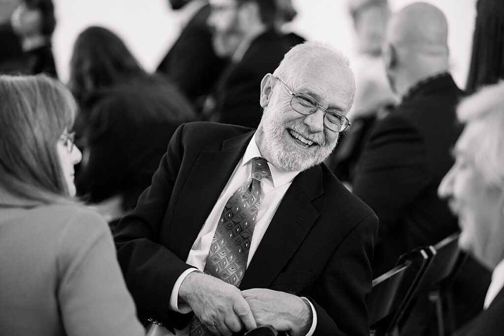 Wedding guest leaning over chair laughing