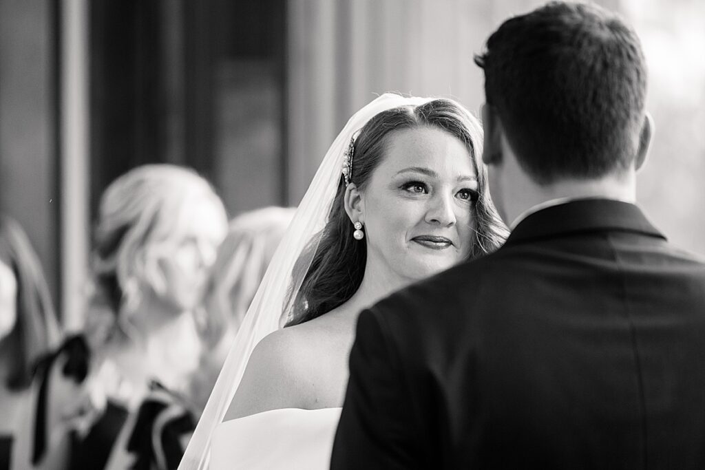 Bride smiling up at her groom during wedding ceremony