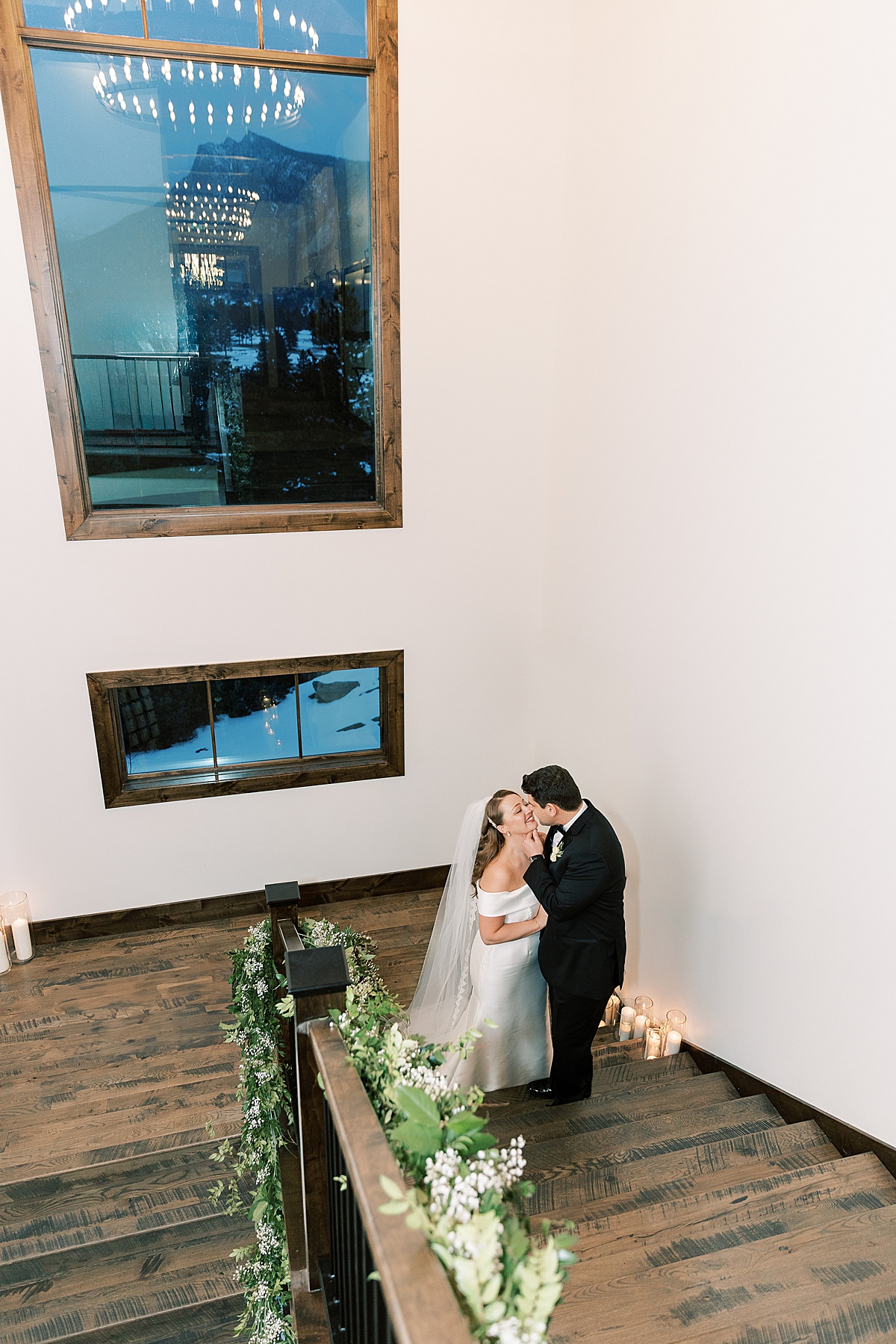 Bride and groom sharing a kiss at the bottom of staircase