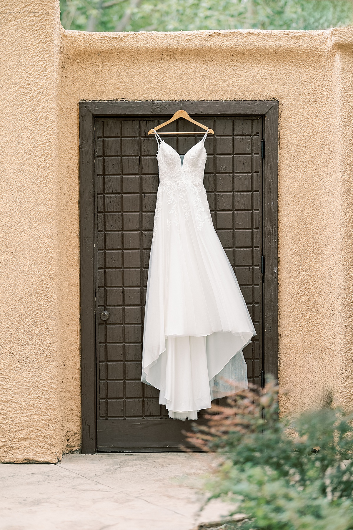 Wedding dress hanging from brown door