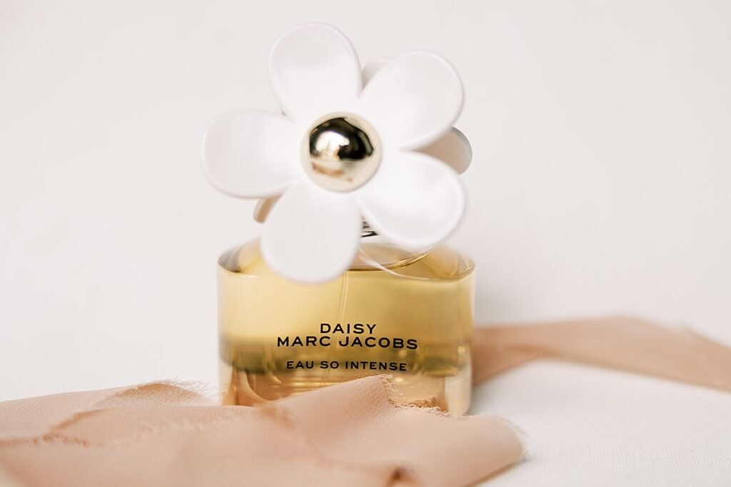 Daisy Marc Jacobs perfume sitting in a pink ribbon