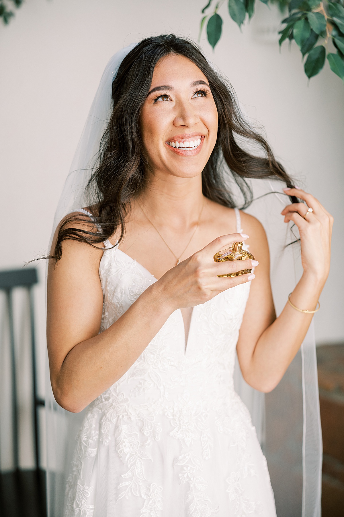 Bride spraying perfume and holding back her hair