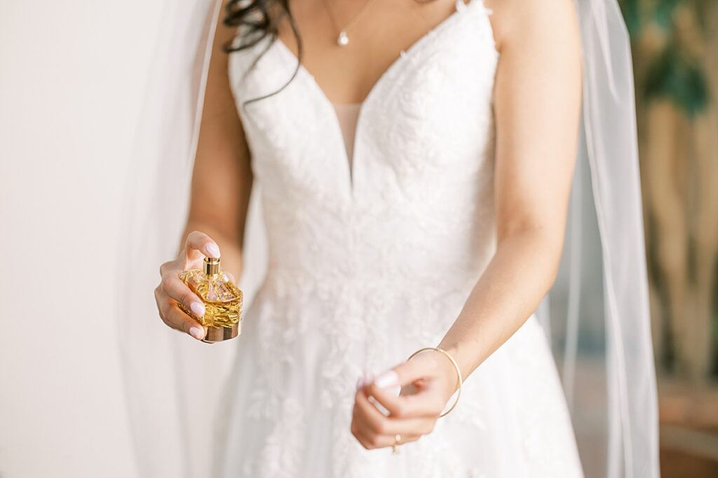 Bride spraying perfume on wrist