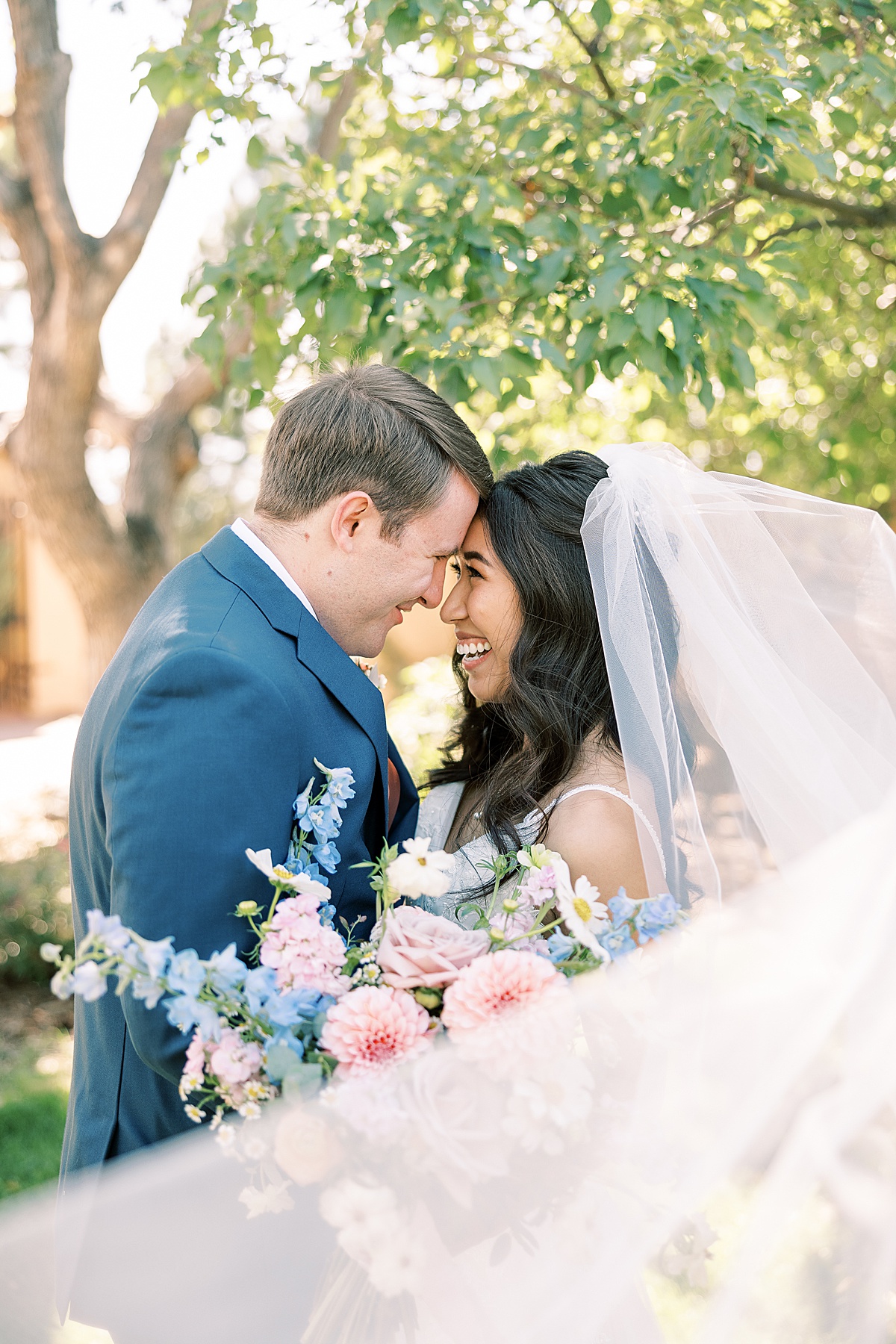 Veil blowing over bride and groom