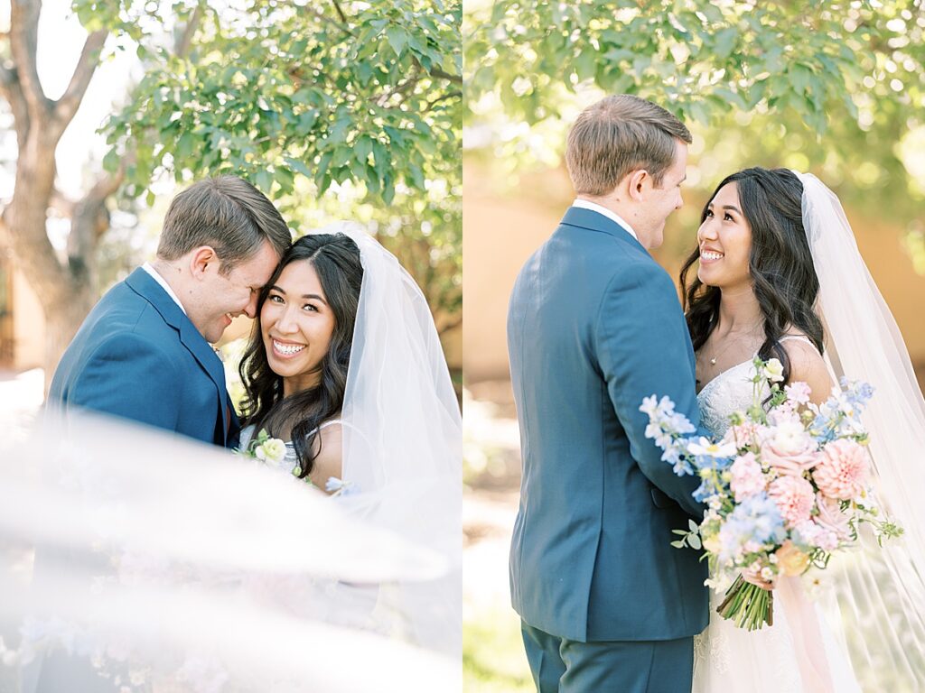 Bride in white dress and groom in blue suit posing for wedding portraits