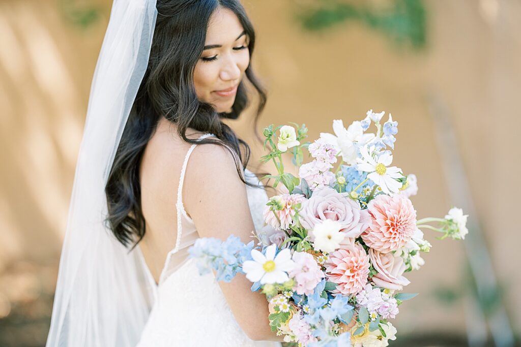 Bride holding her flowers and looking down over her shoulder