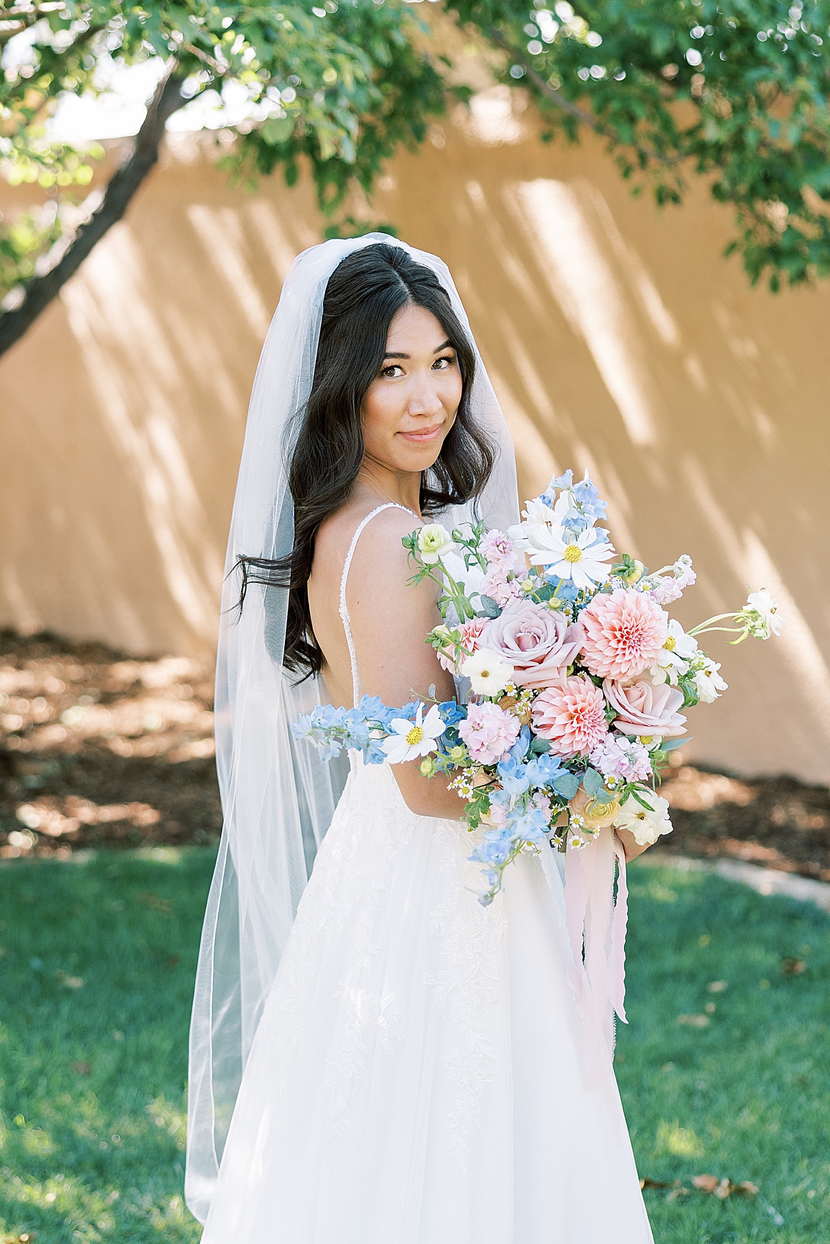 Bride looking up at camera holding flowers