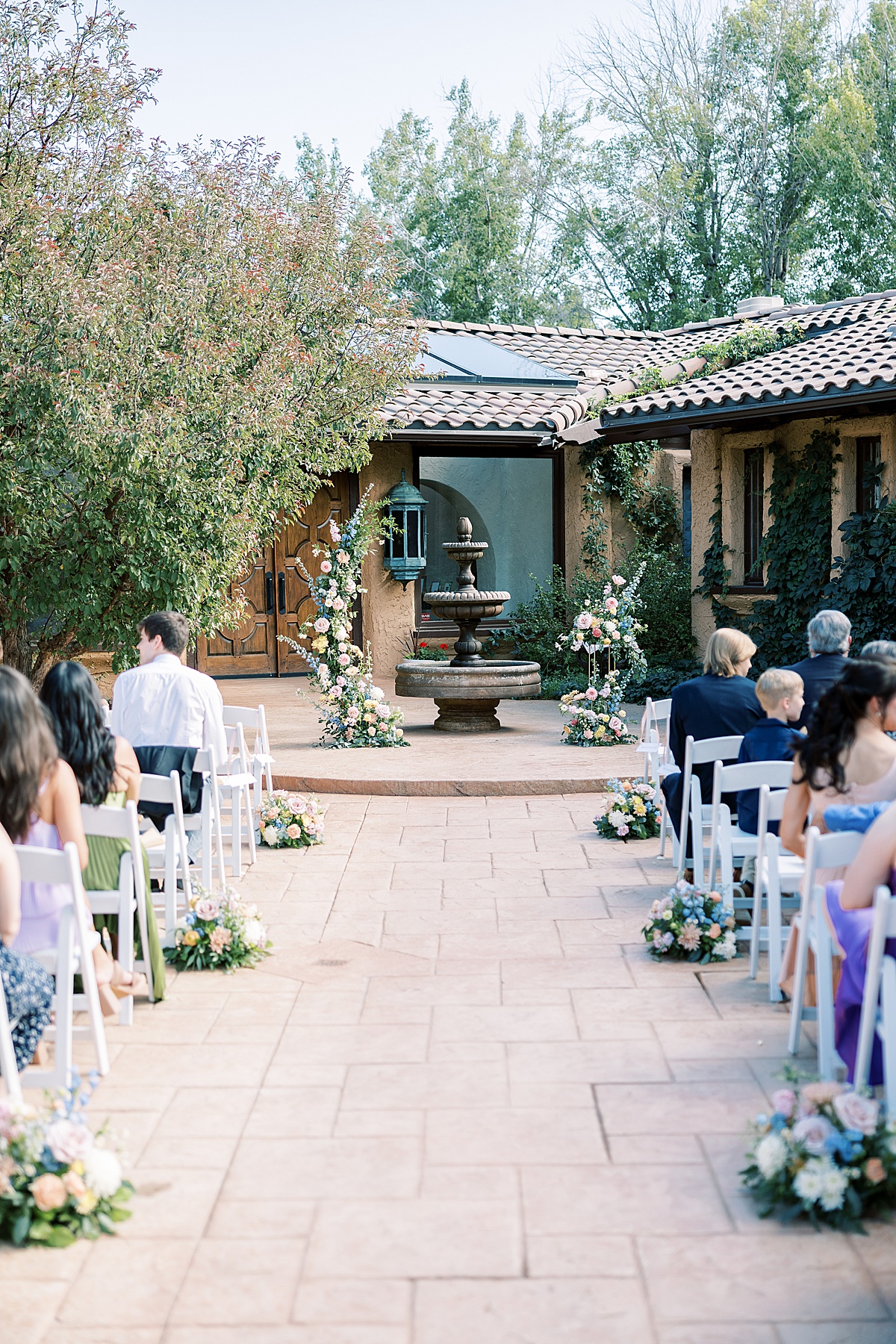 Wedding ceremony with guests sitting in white chairs