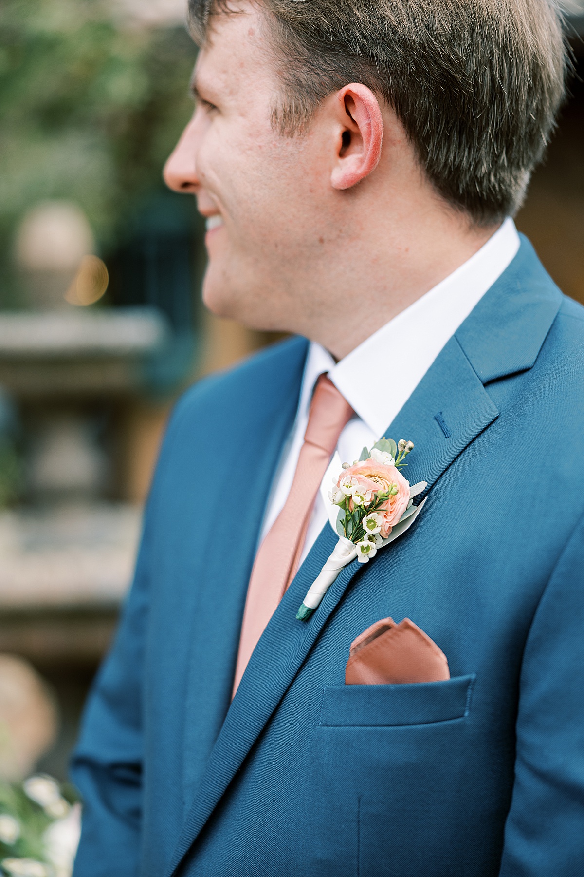 Groom in blue suit looking away from camera