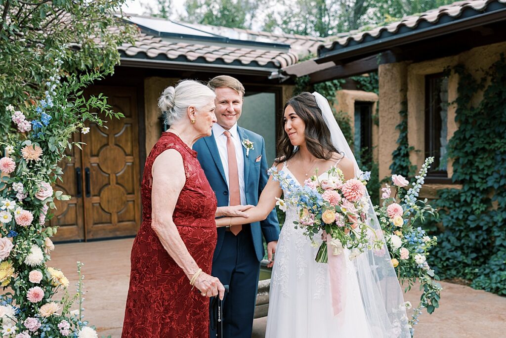 Bride and groom greeting guest in red dress