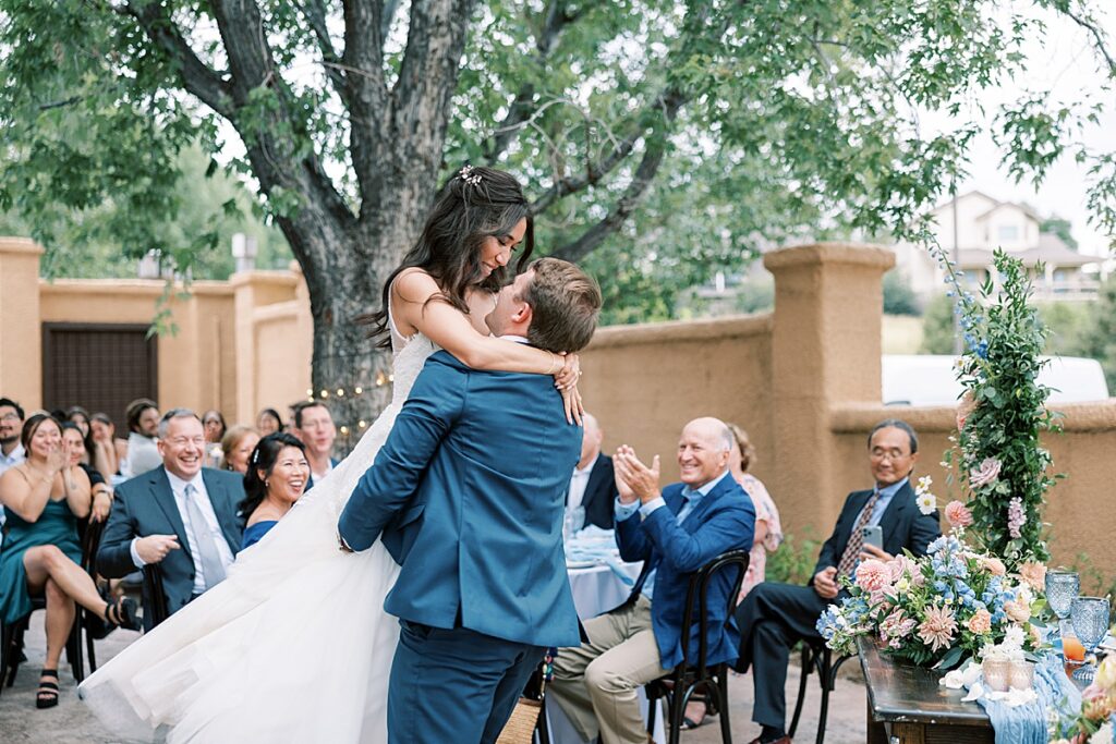 Groom holding up bride during first dance