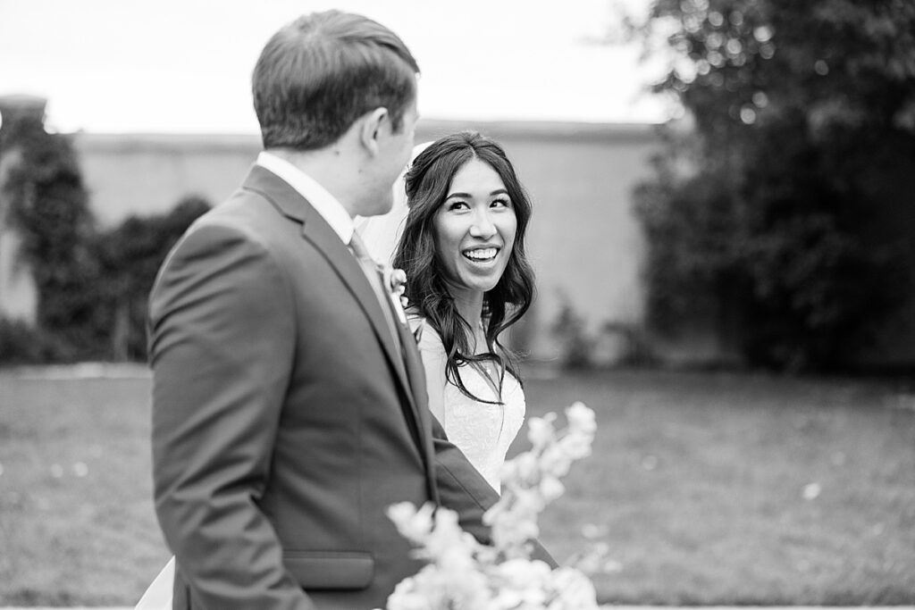 Black and white photo of bride smiling up at groom