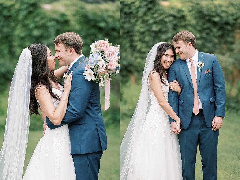 Bride with arm wrapped around groom in blue suit with flowers over his head