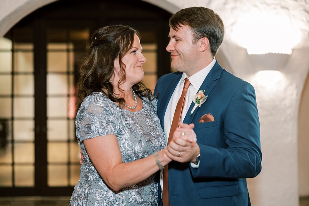 Mother in gray suit and man in blue suit dance