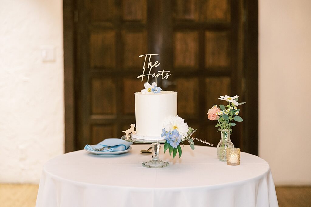 Wedding cake with "The Harts" written on top in front of brown door