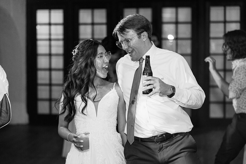 Black and white photo of wedding couple and groom holding beer