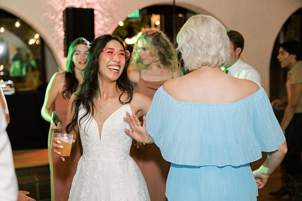 Bride dancing with wedding guest in blue dress