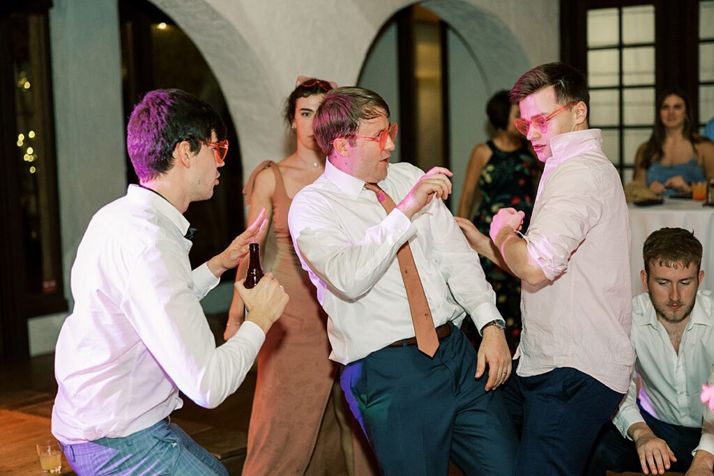 Man in salmon tie dancing at wedding reception