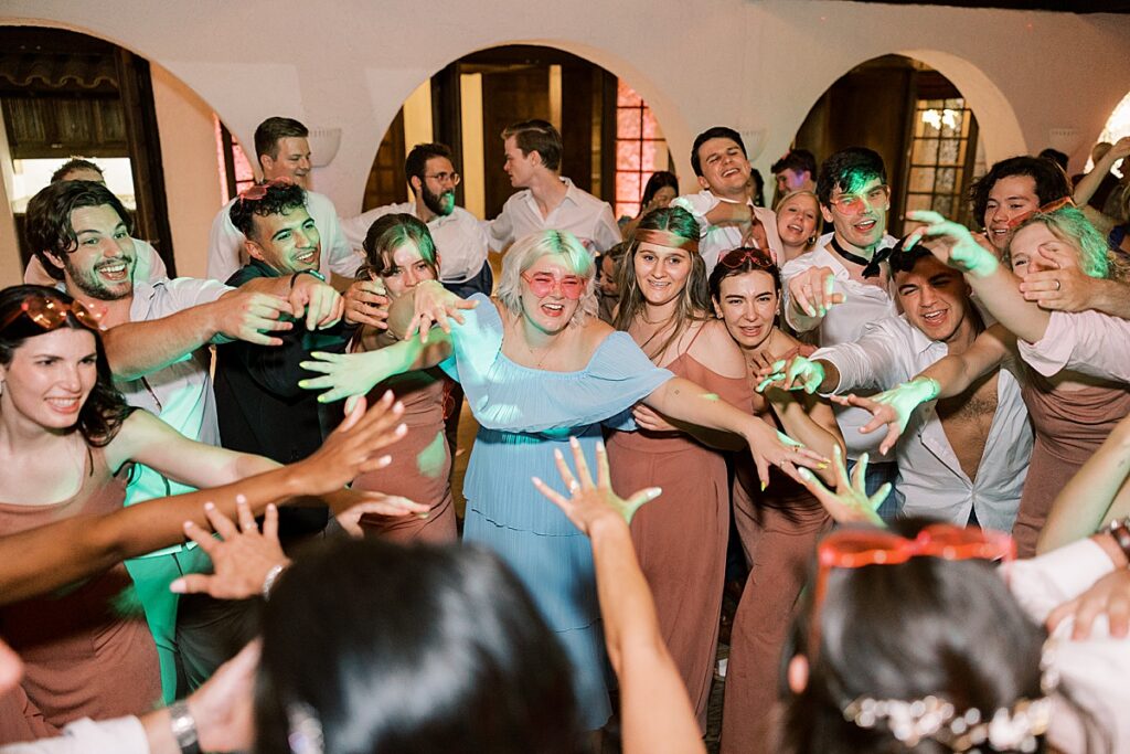 Large group dancing with woman in blue dress in the middle