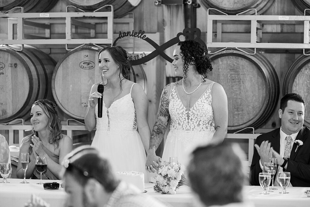 Bride holding hands with her wife while giving a toast