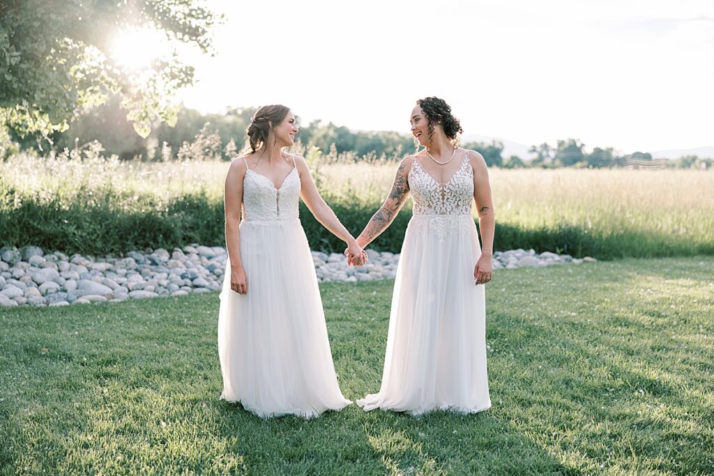 Woman walking holding hands with another woman on grass