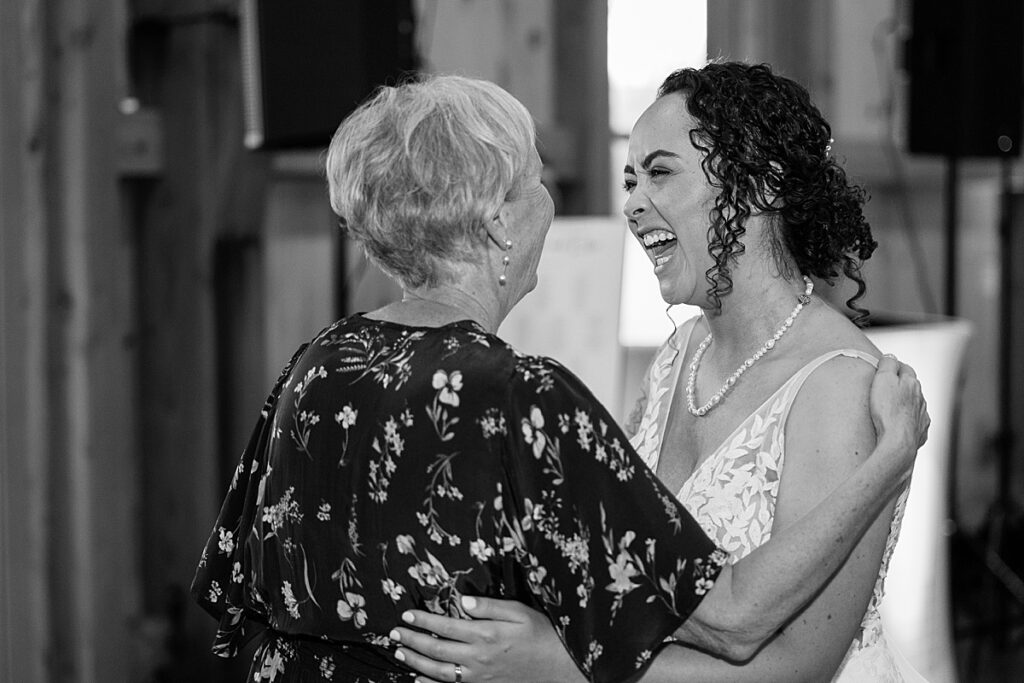 Woman laughing and smiling at woman in dark dress