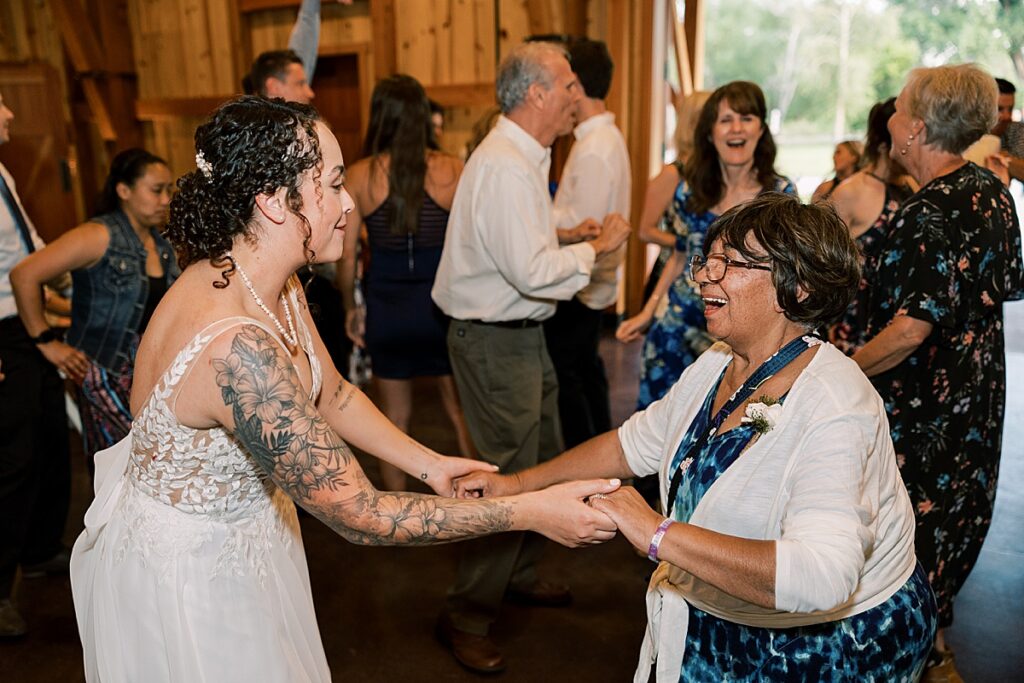 Woman dancing with shorter woman in blue dress and white sweater