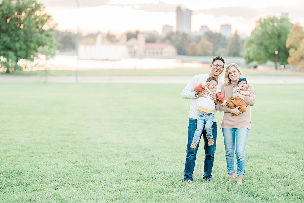 Man and woman holding toddler and baby looking at camera