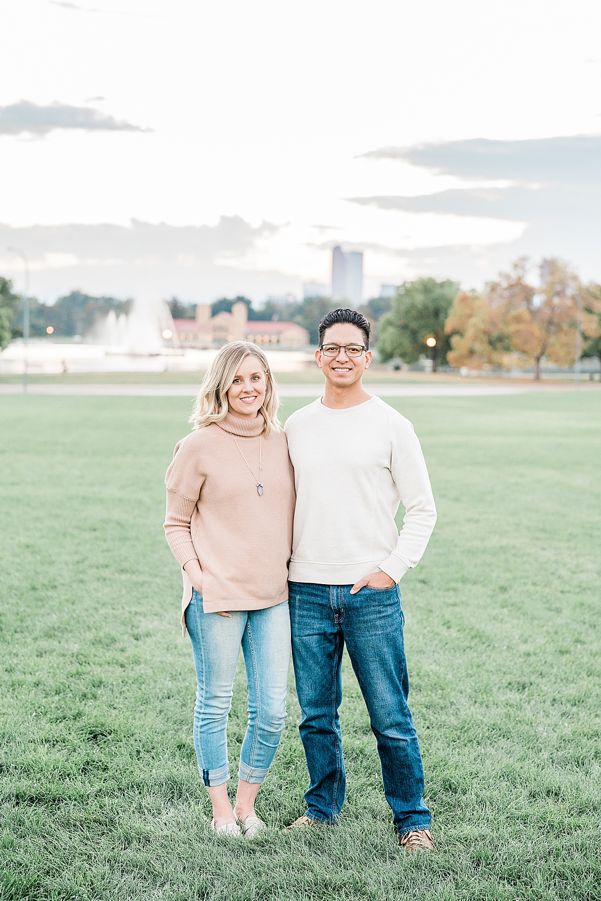 Man in white sweater and woman in pink sweater standing with arms around each other