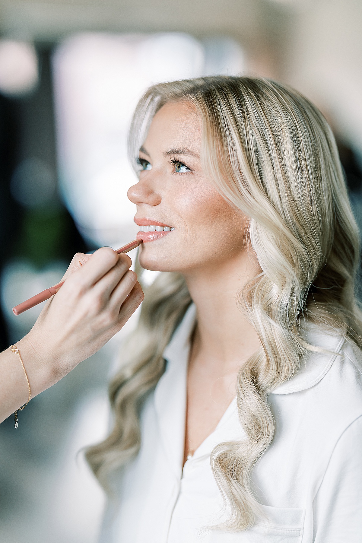 Bride with blonde hair getting makeup done