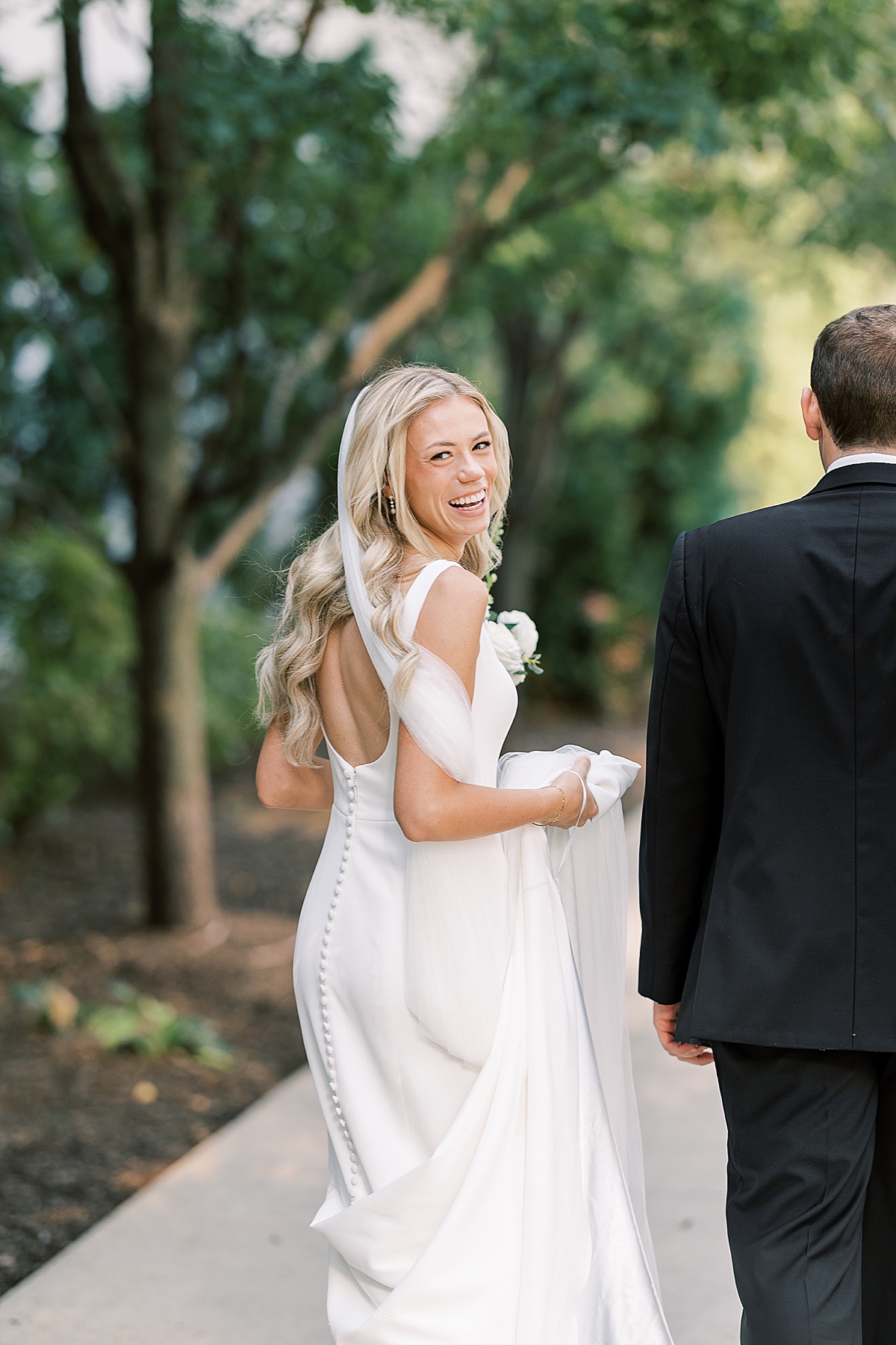 Bride smiling over her shoulder while walking away