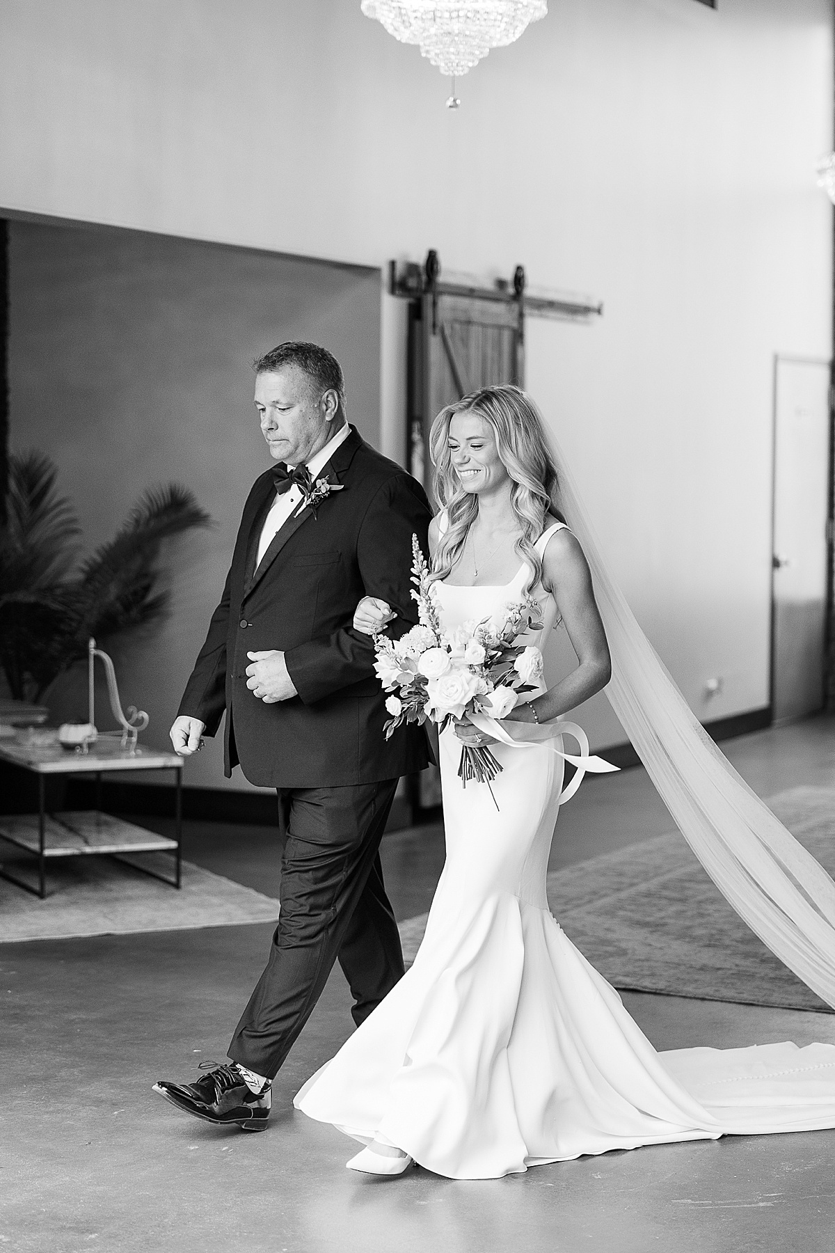 Black and white photo of Dad walking bride down aisle