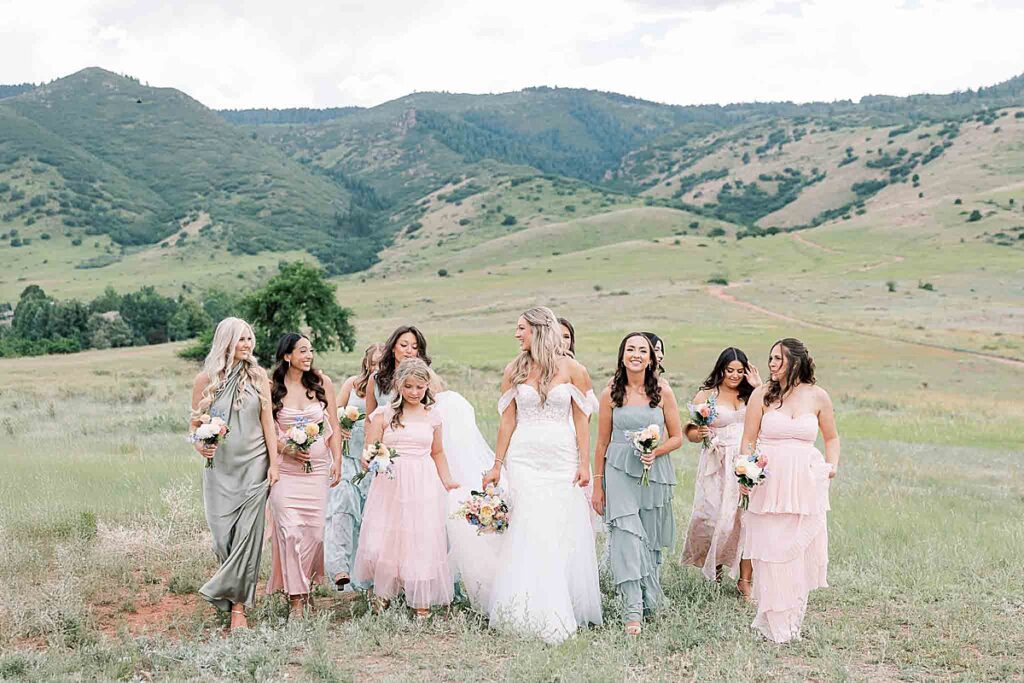 Bride and bridesmaids walking through field