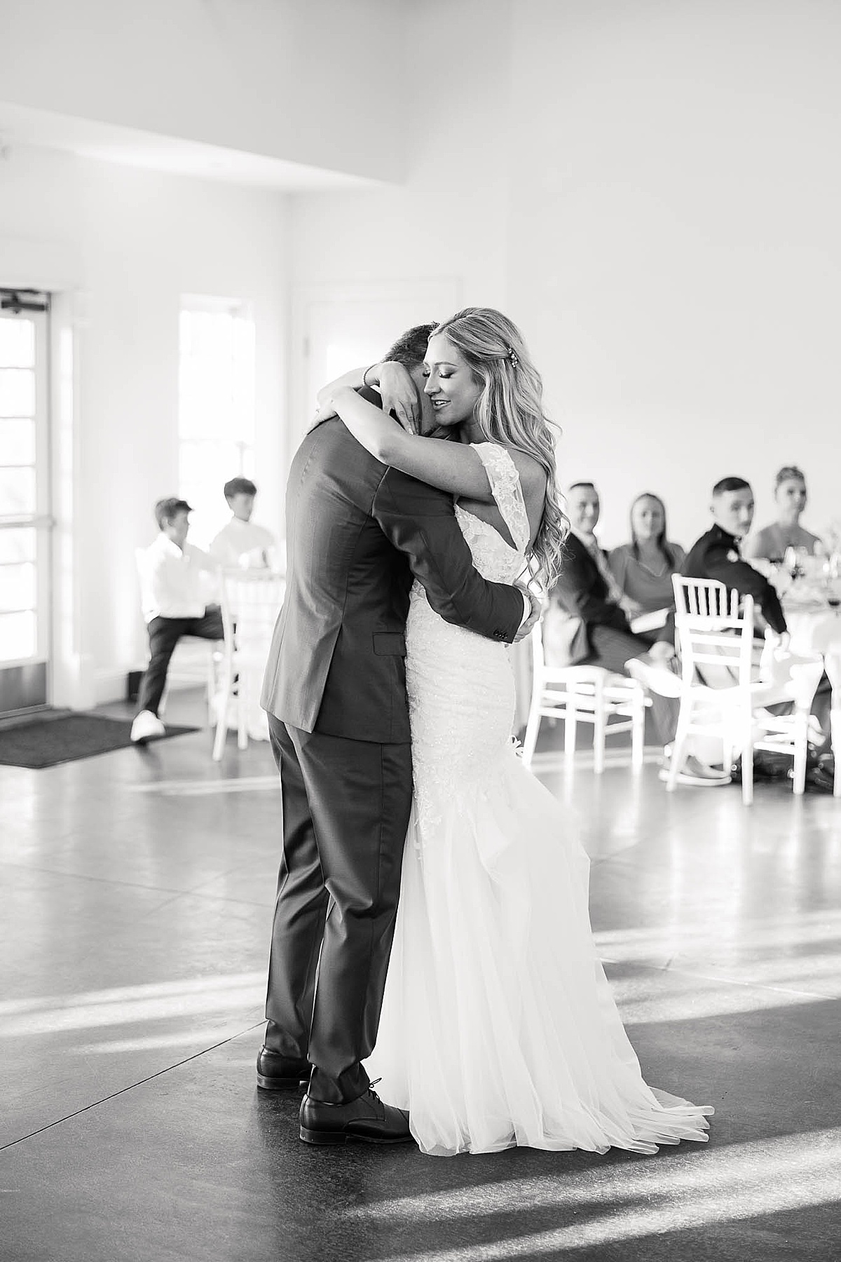 Black and white photo of couple hugging during their first dance