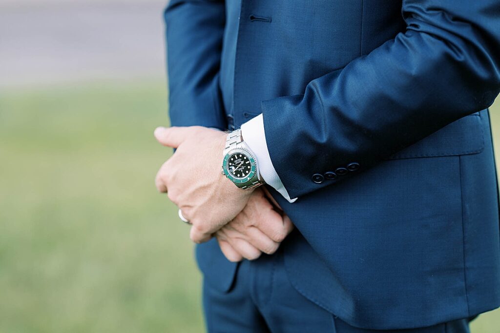 Groom in blue suit wearing Rolex watch